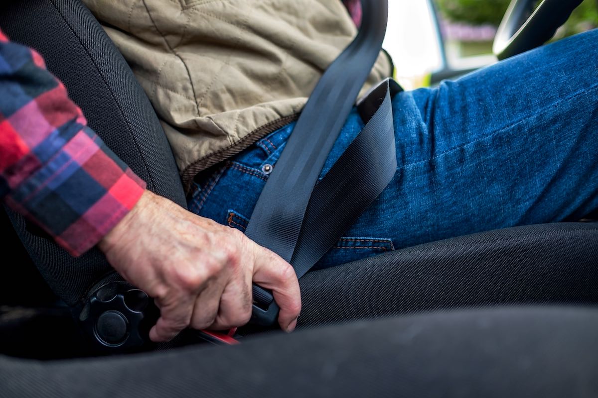 A man fastening seat belt in car.