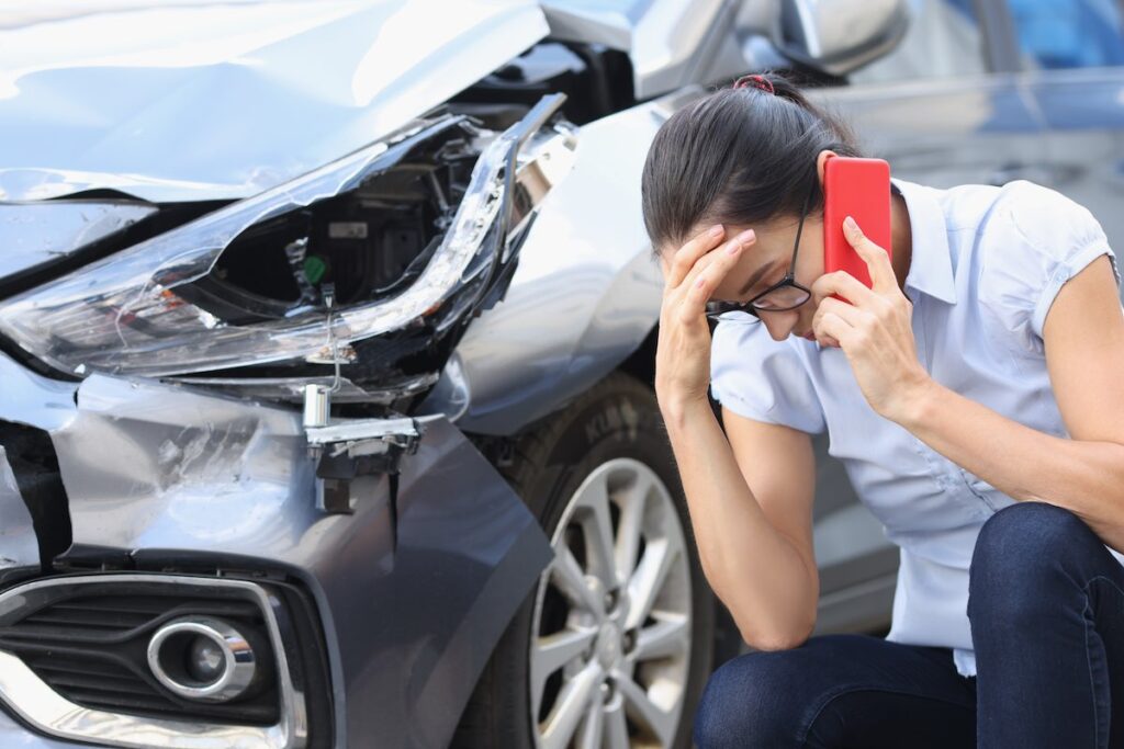 Upset woman talking on phone after a car accident in Chandler
