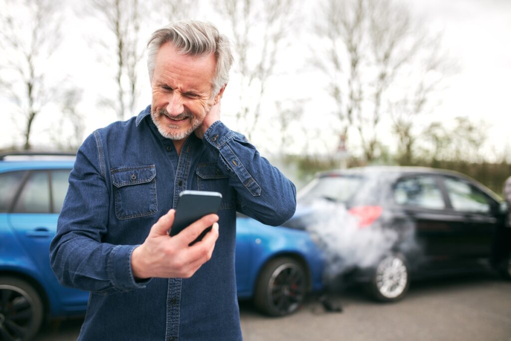 A senior male driver calling for help after a car accident