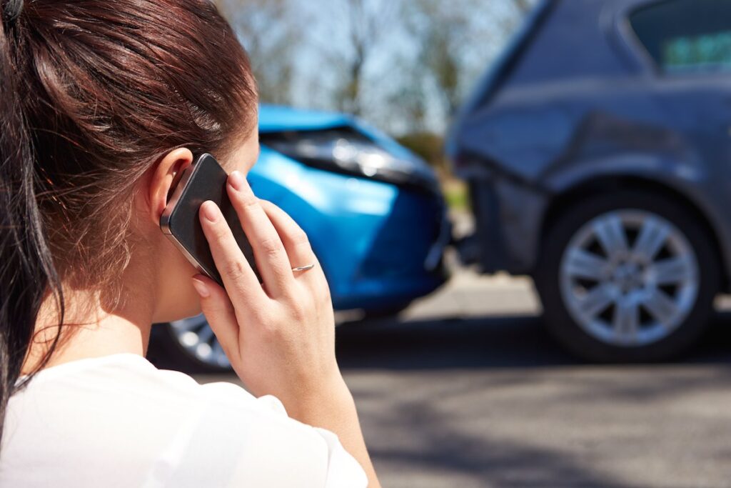 Female driver making a phone call after a road accident