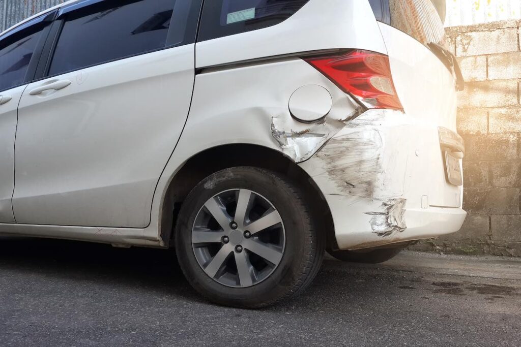 Close-up image of a damaged white car after a road accident