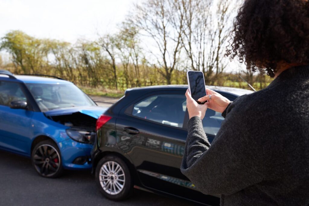 Female driver taking photos of road traffic accident