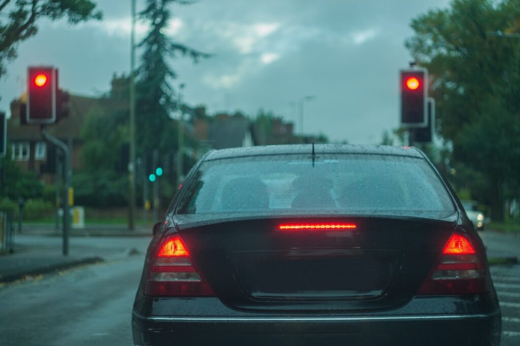 Displaying stop lights, traffic red light and rear view of a car