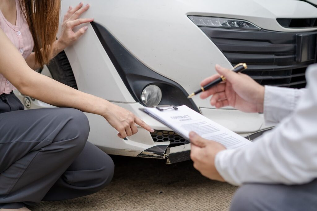 Geico insurance agent checking the broken car