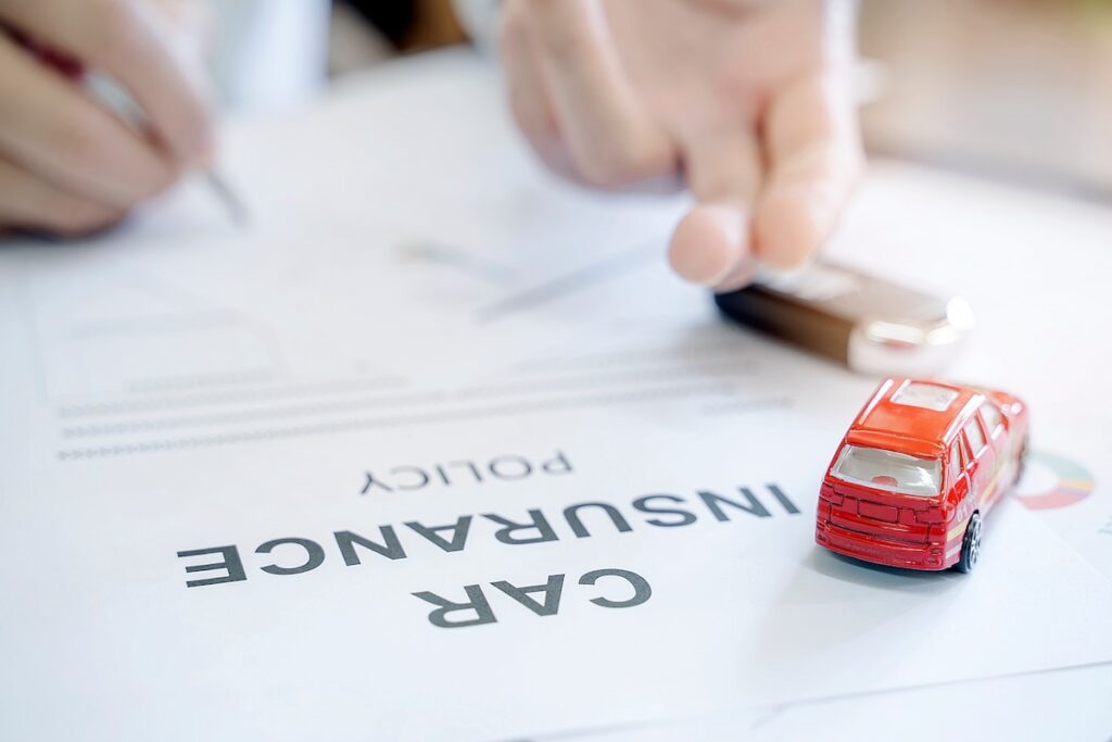 Reading State Farm car insurance policy with red car toy