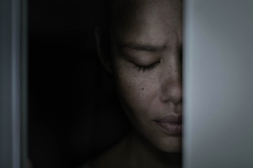 A scared depressed native American woman hiding in the closet