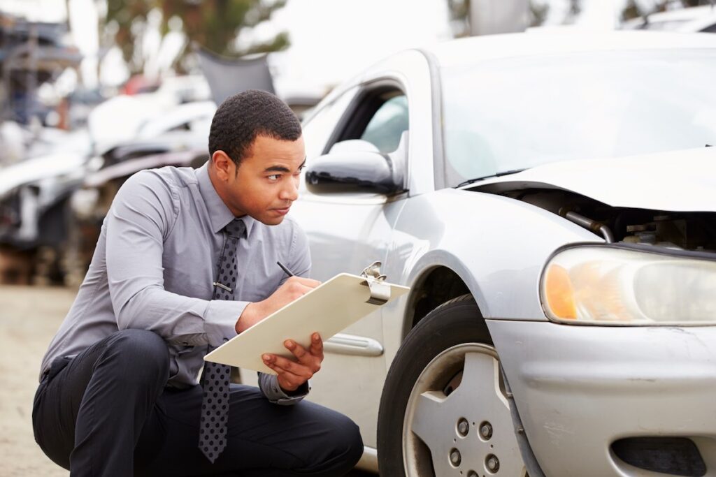 Allstate loss adjuster inspecting the car after a road accident