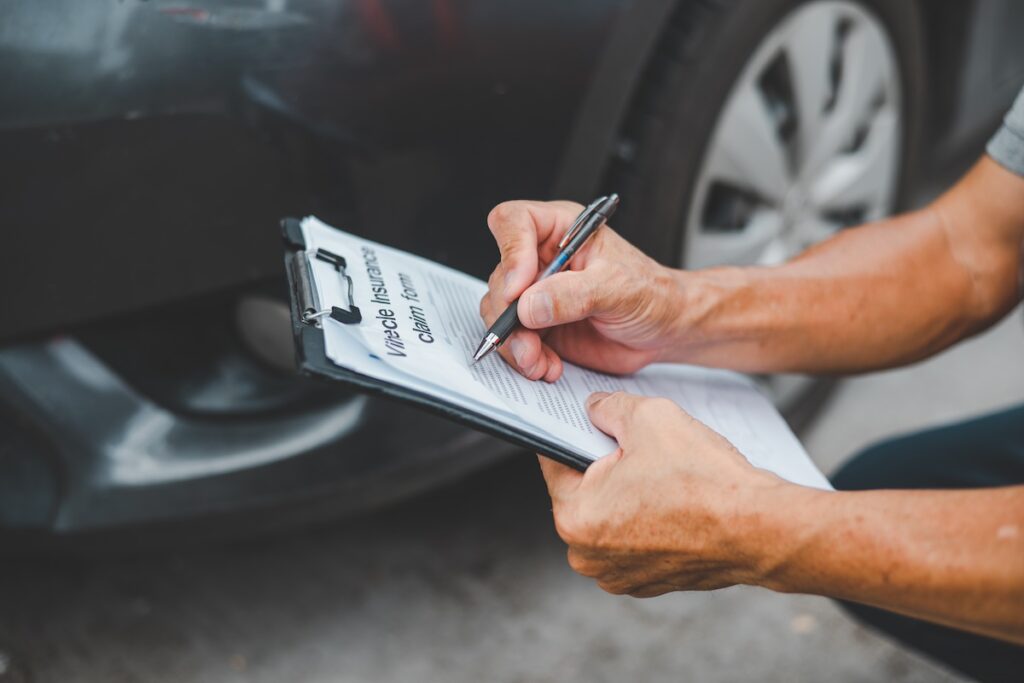 American Family insurance officer inspecting a customer's car that had an accident