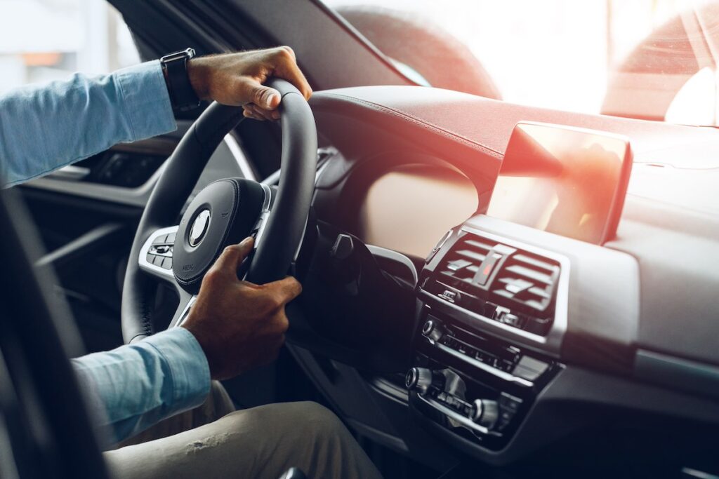 Male hands holding steering wheel turning to the right