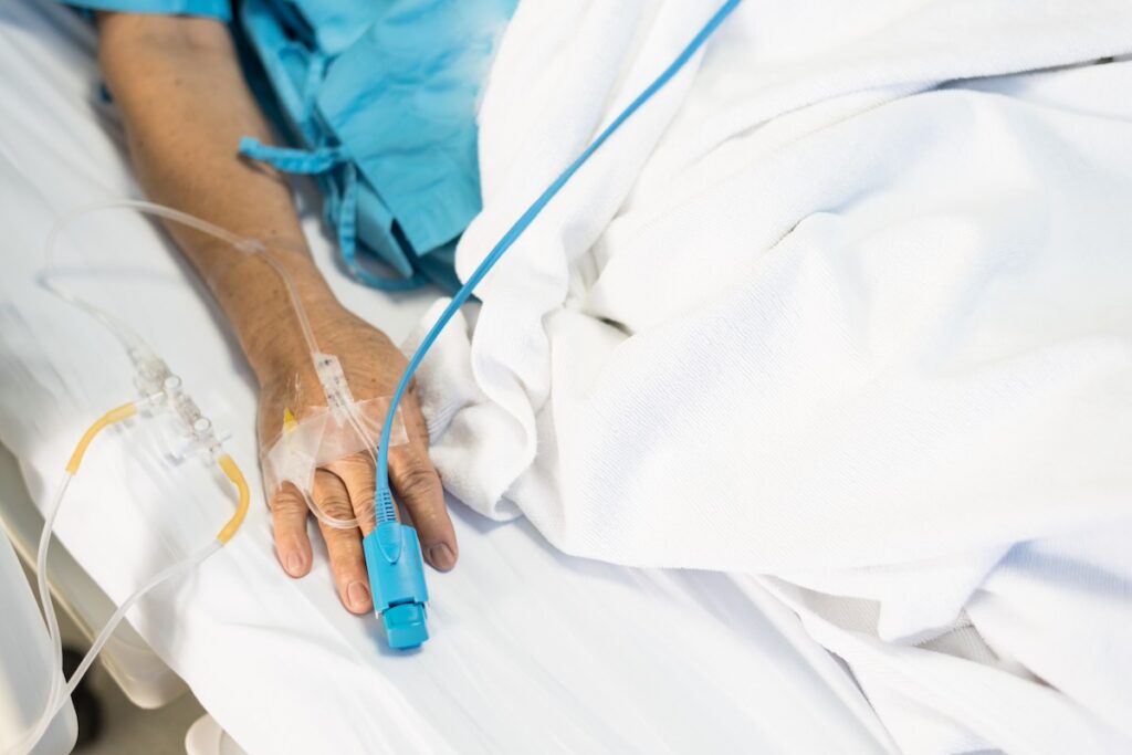 Close up of an old woman patient hand with iv fluid drip recovering from a possible poisoning in Texas